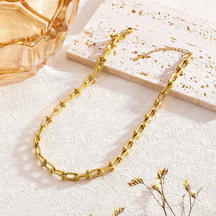 Detailed view of gold link chain. Lumiere necklace & bracelet set, elegant women's jewelry accessory.