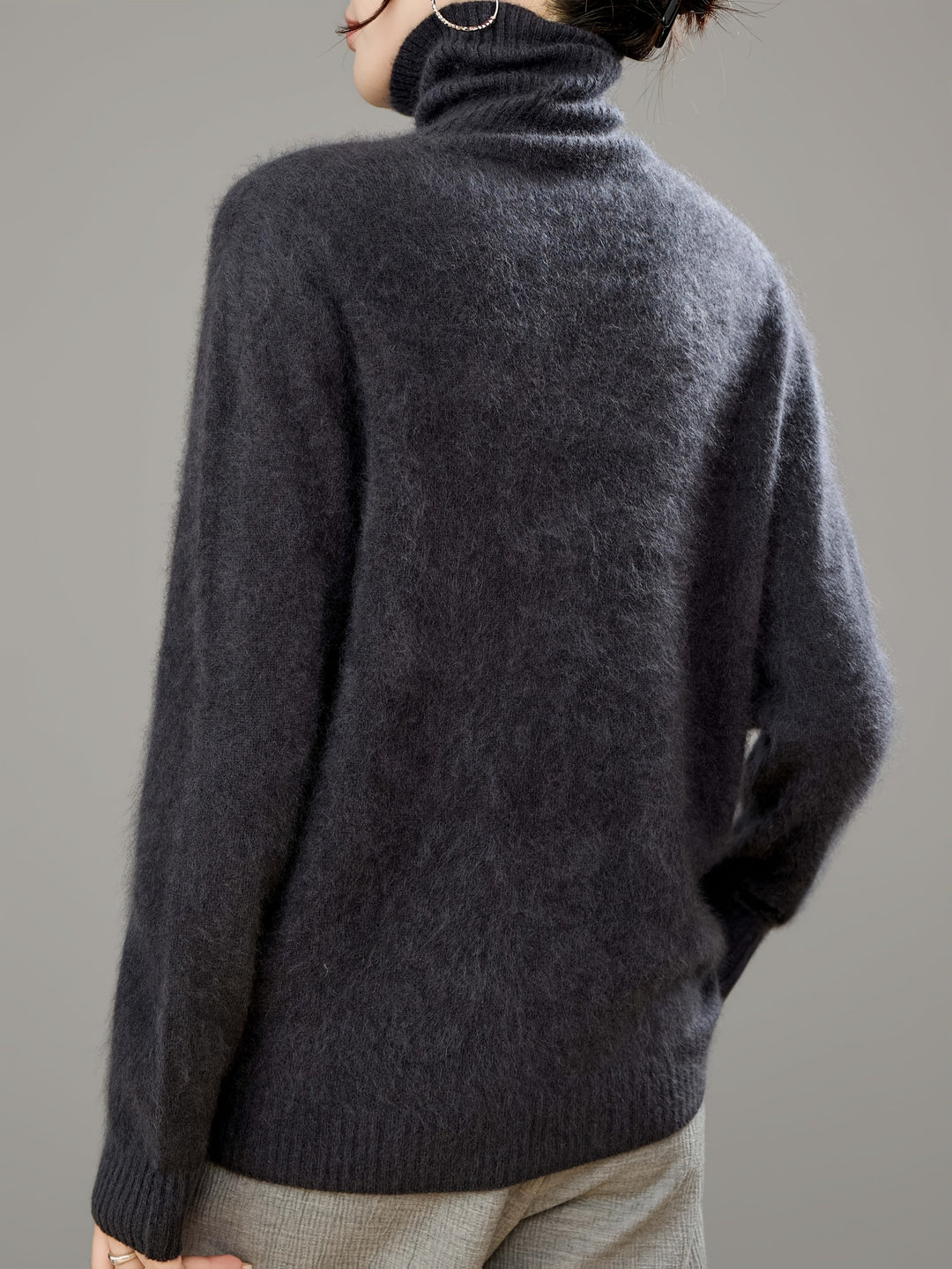 Close-up of soft knit on a women's oversized turtleneck sweater, cozy and luxurious.