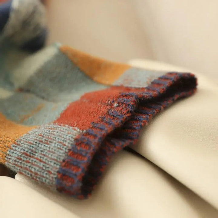 Hand touching a soft women's cashmere roll neck sweater, indicating luxury feel