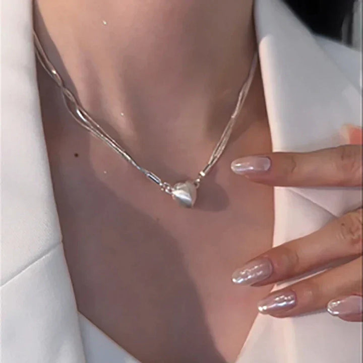 Close-up of women's magnetic love heart pendant necklace, sterling silver, showing the interlocking design.