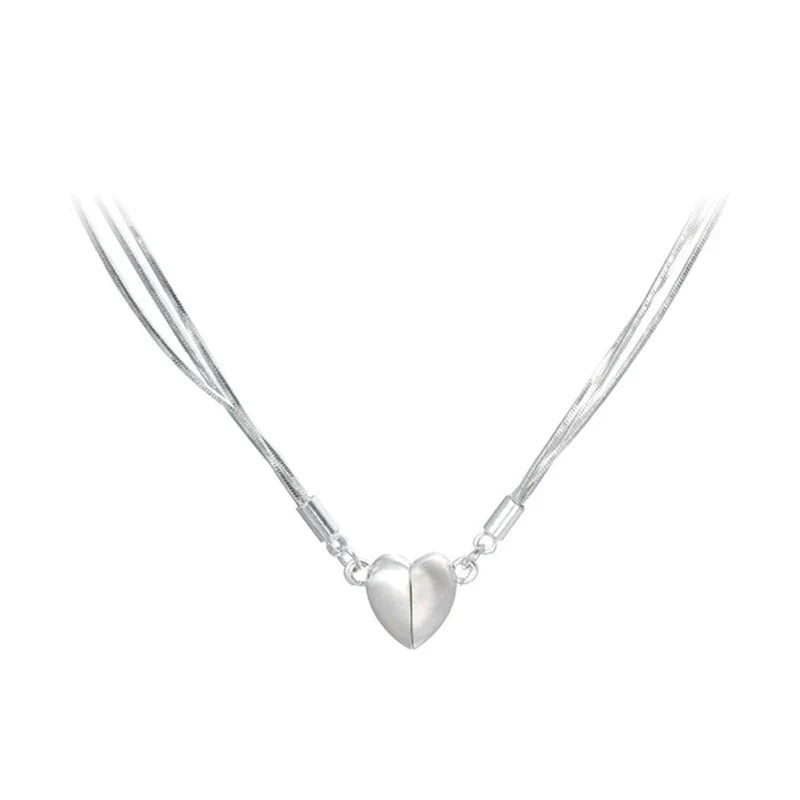 Two halves of a sterling silver magnetic love heart pendant forming a complete necklace for women, stylish jewelry.