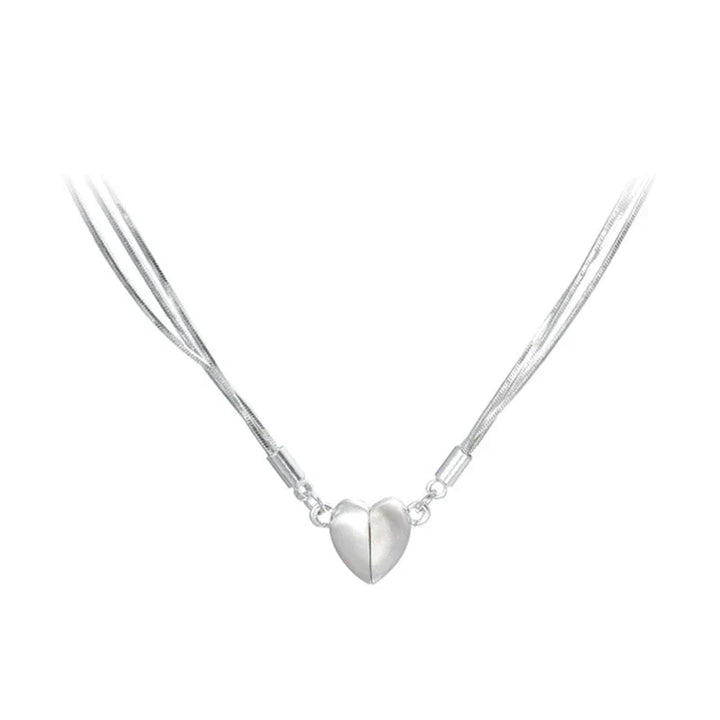 Two halves of a sterling silver magnetic love heart pendant forming a complete necklace for women, stylish jewelry.