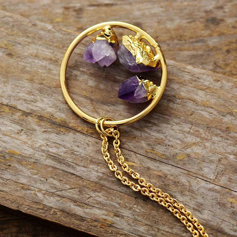 Close-up of a raw amethyst crystal gemstone pendant on a delicate silver-plated chain, minimalist women's jewelry.