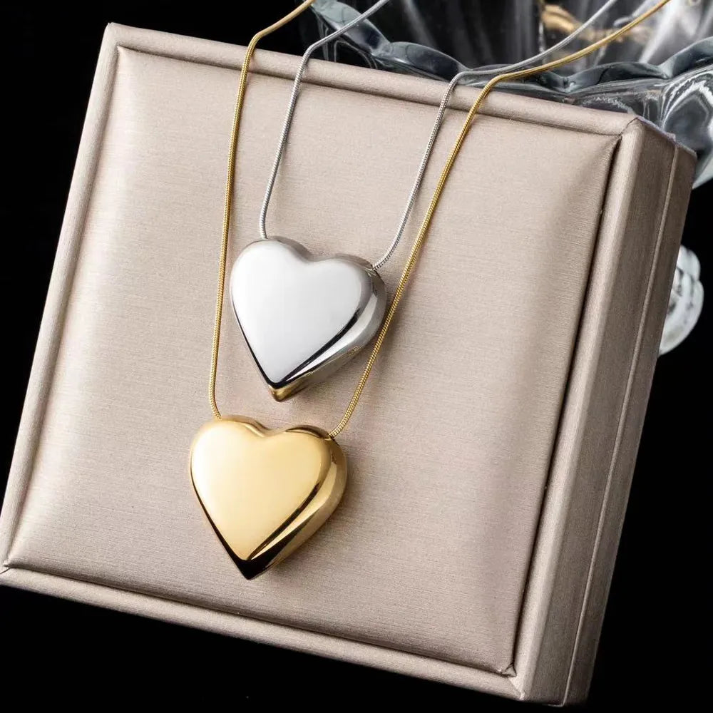 Women's minimalist stainless steel heart pendant necklace. Elegant, simple peach heart jewelry, perfect gift.