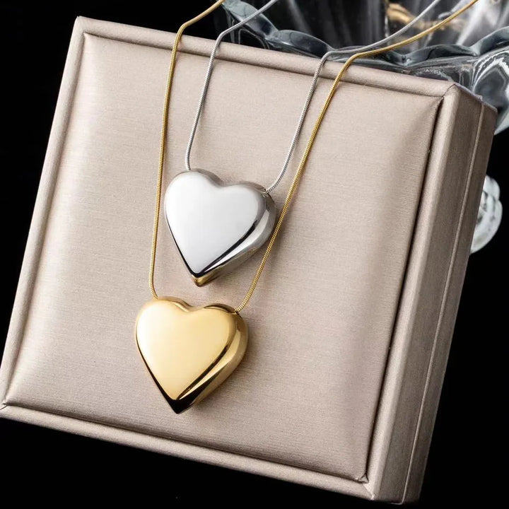 Women's minimalist stainless steel heart pendant necklace. Elegant, simple peach heart jewelry, perfect gift.