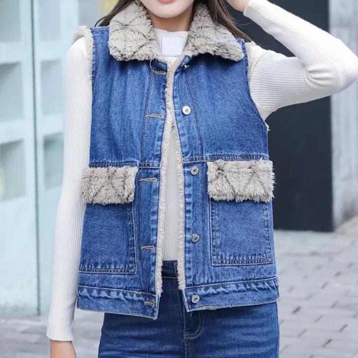Close-up of a blue denim women's gilet, showcasing modern style & durable fabric. Versatile sleeveless jacket.