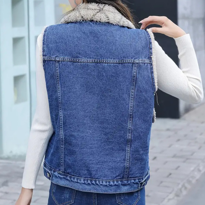 Stylish woman wearing a blue denim gilet over a long-sleeve top. Modern layering piece for casual fashion.