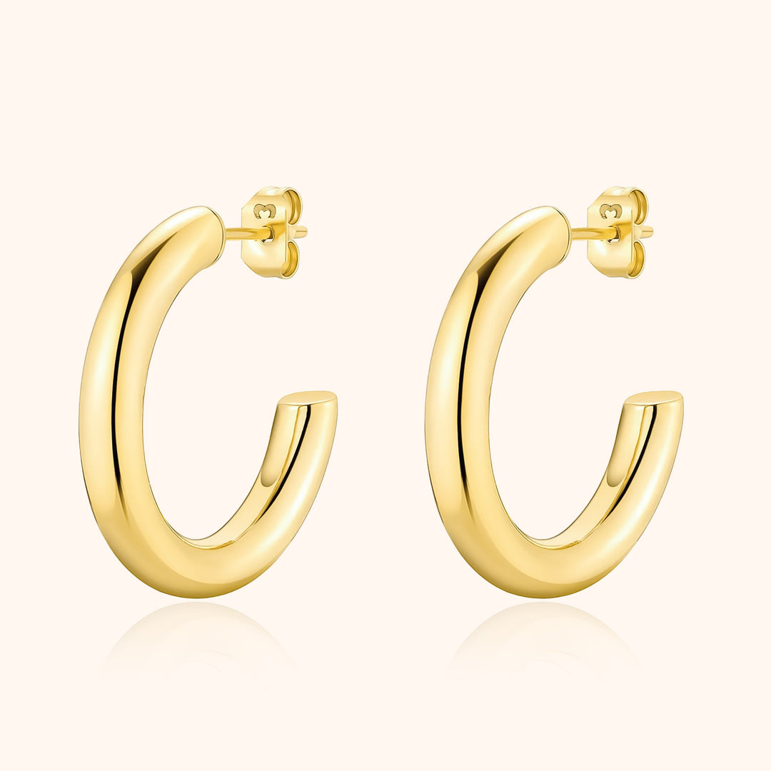 Women's modern half-round hoop earrings in sterling silver, a minimalist and elegant everyday jewelry choice.