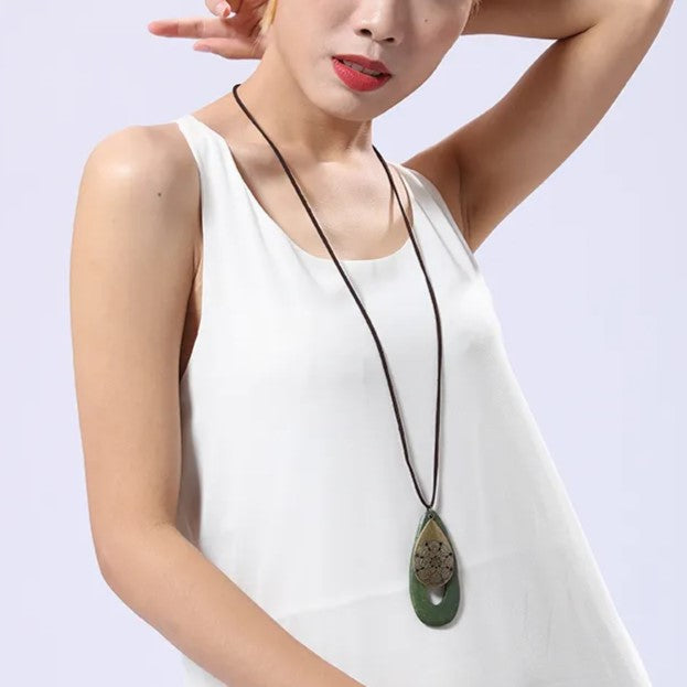 Women's eco-friendly bohemian oval wood necklace, natural wooden pendant accessory.