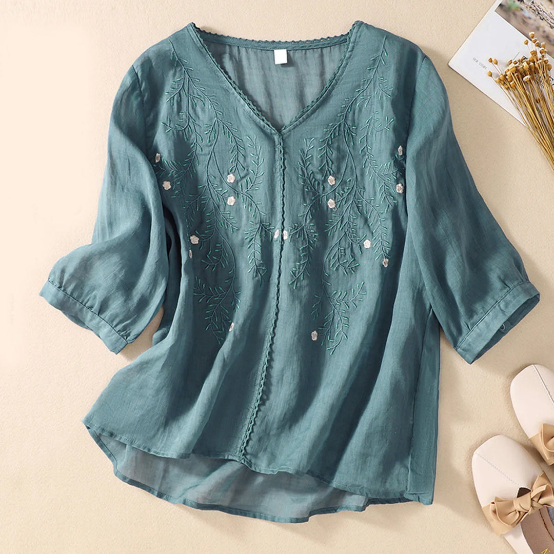 Women's nature-inspired embroidered blouse, delicate floral design, comfortable flowy fit, chic summer style.