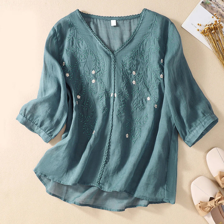 Women's nature-inspired embroidered blouse, delicate floral design, comfortable flowy fit, chic summer style.