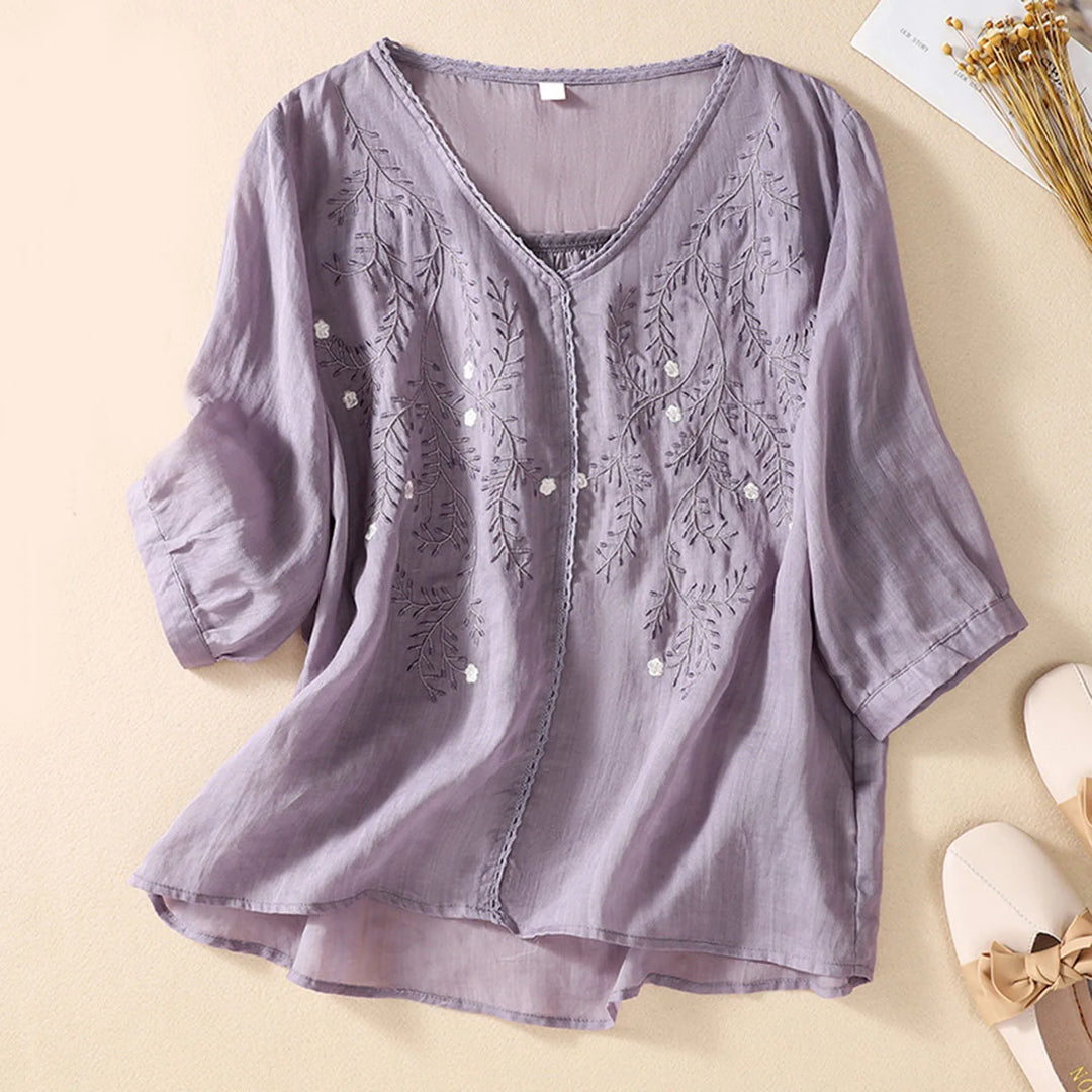 Colorful women's embroidered blouse with delicate nature motifs, elegant summer top for versatile casual or chic wear.