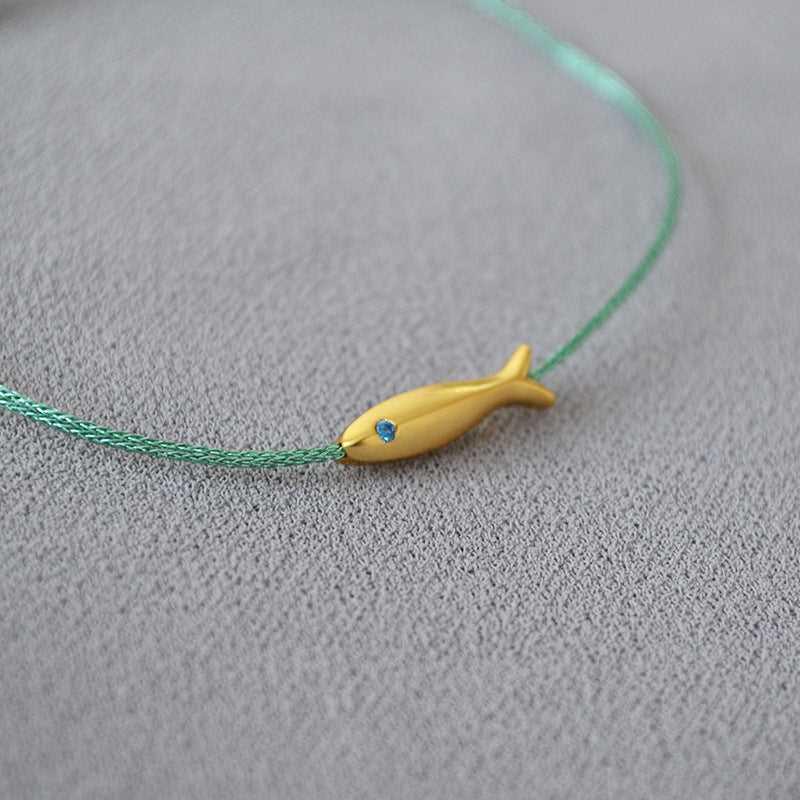 Close-up of adjustable silver Ocean Dream bracelet for women, features delicate goldfish charm, casual accessory