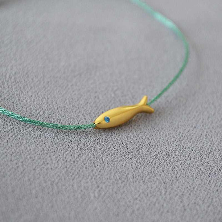 Close-up of adjustable silver Ocean Dream bracelet for women, features delicate goldfish charm, casual accessory