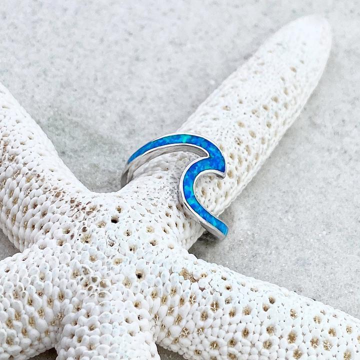Elegant women's opal ring with a flowing ocean wave design, crafted from sterling silver.