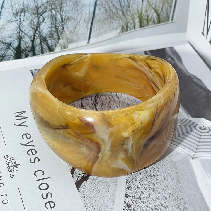 Sculptural women's irregular bangle bracelet with a rich marble pattern, an elegant lightweight acrylic accessory.