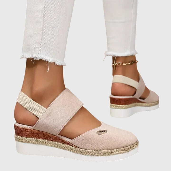 Woman walking outdoors in comfortable women's orthopedic sandals with cushioned support.