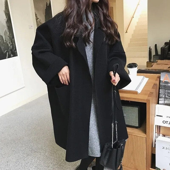 Stylish women's oversized trench coat in classic design, featuring a double-breasted front and long elegant cut.