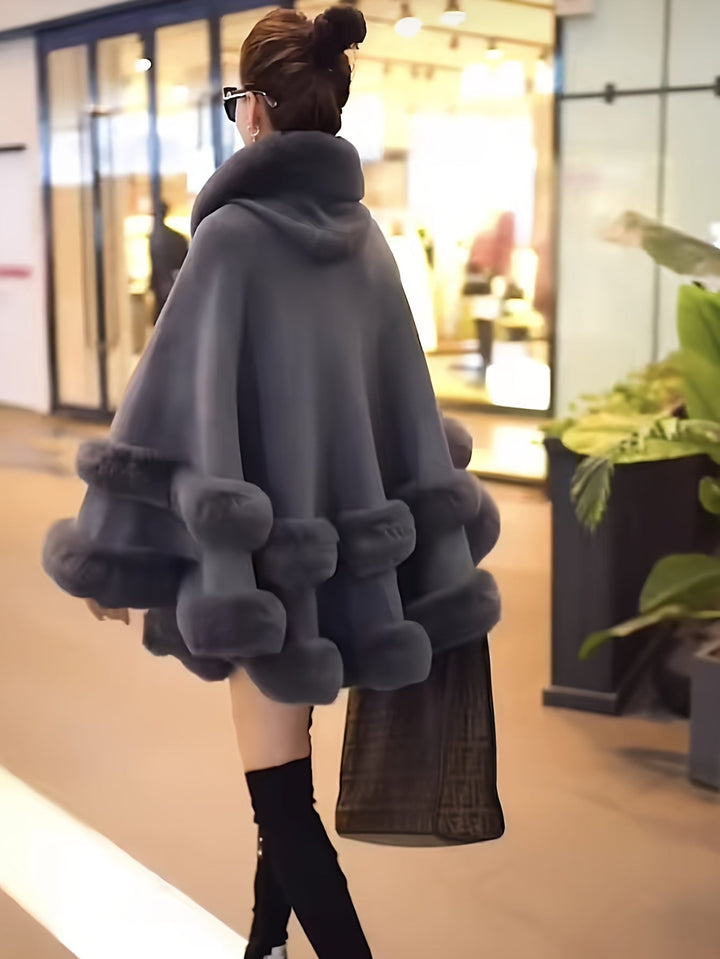 Essential women's oversized hooded cape coat, offering superior warmth and a stylish look for winter.