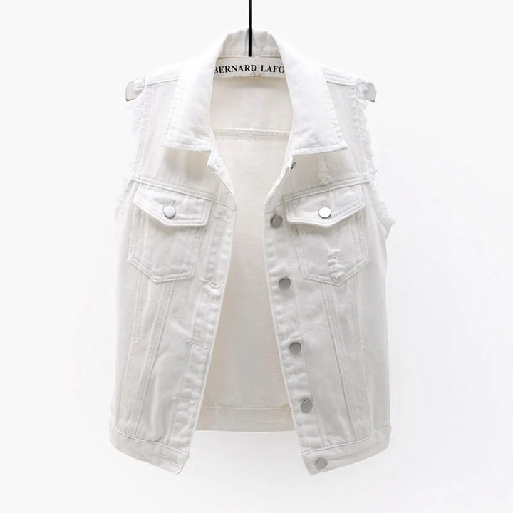 Back view of a women's oversized denim vest with edgy distressed elements.