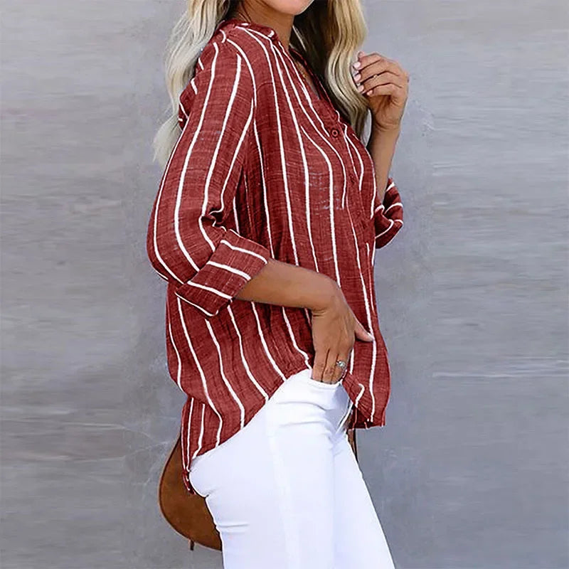 Flat lay of a stylish women's oversized striped top, a versatile long sleeve fashion blouse.