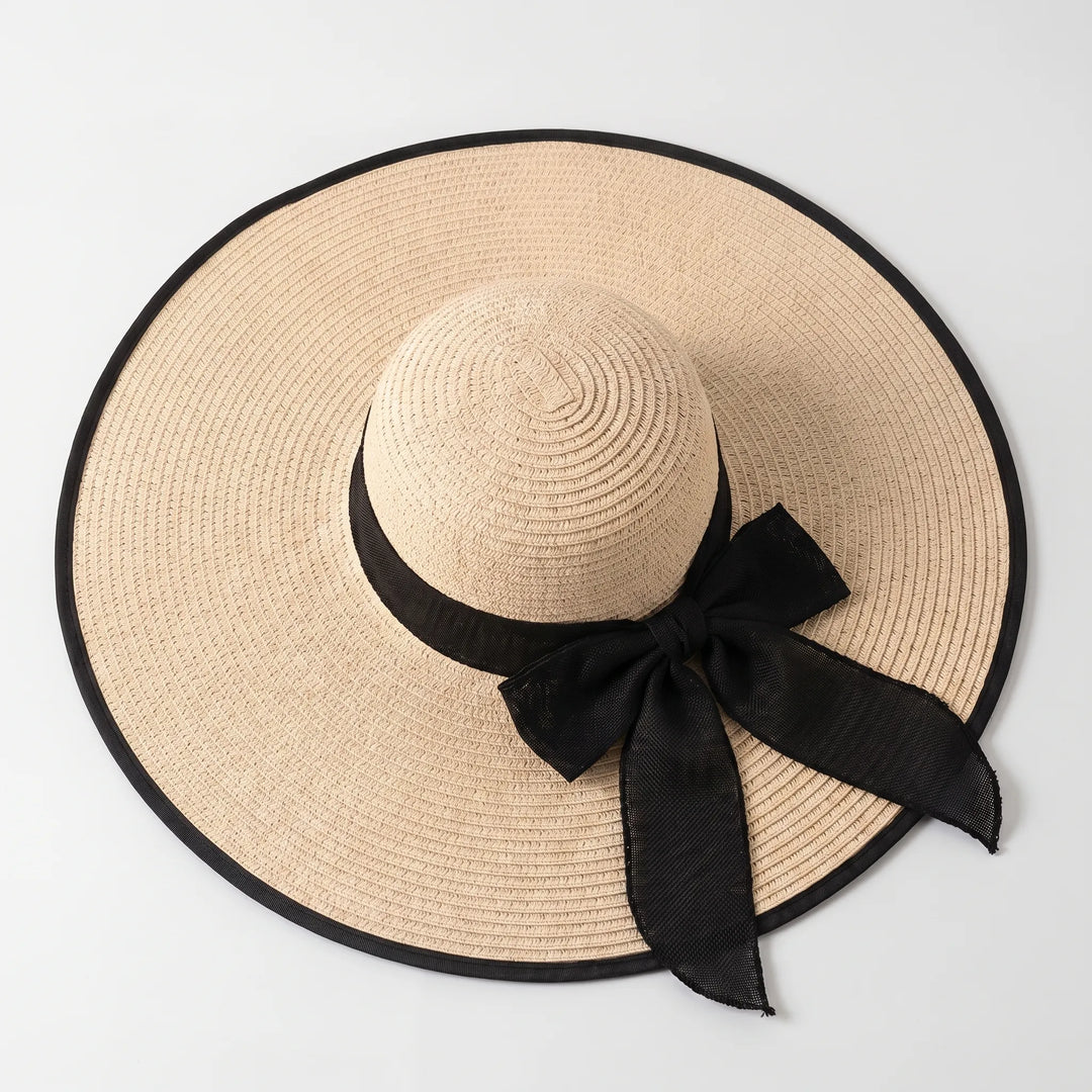 Stylish women's wide brim sun hat with bow detail, essential for summer resort wear.