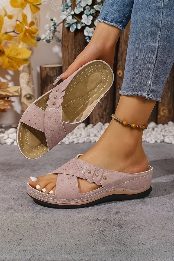 Close-up of women's perforated wedge sandals, highlighting the breathable design and comfortable slip-on fit.