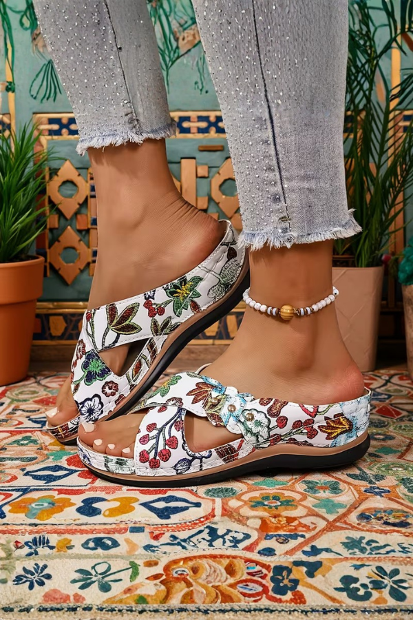 Women's casual slip-on wedge sandals with perforated details. Offers cushioned support and lightweight summer comfort.