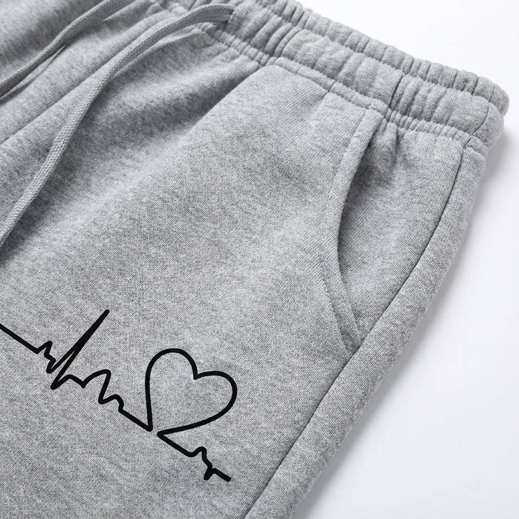 Stylish womens cotton joggers in light pink with small white heart, perfect for comfort