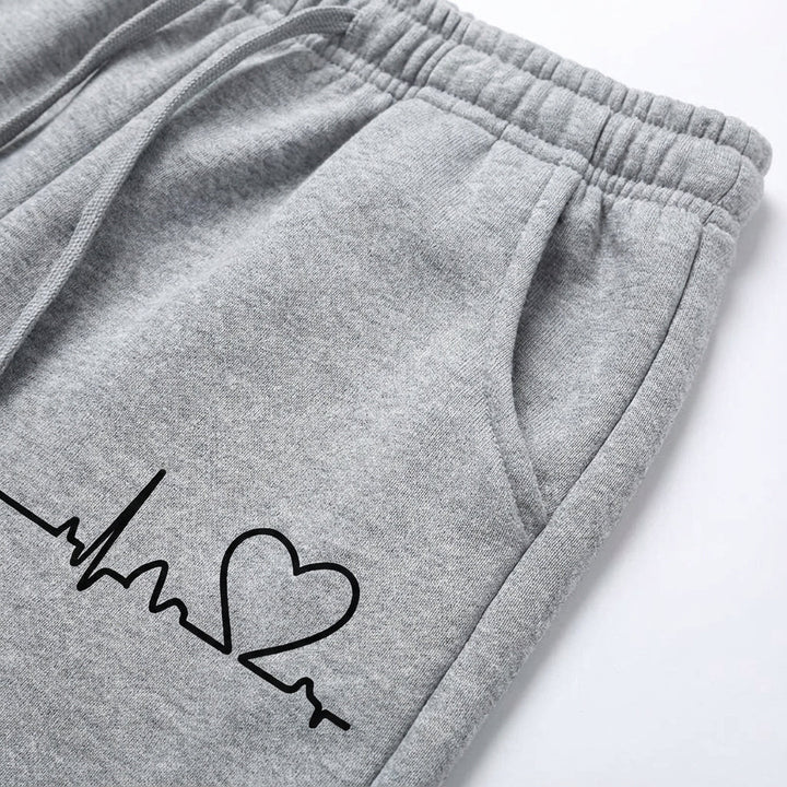 Stylish womens cotton joggers in light pink with small white heart, perfect for comfort