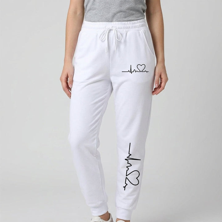 Soft pink cotton women's trousers featuring a delicate heart motif, suitable for sports or relaxing