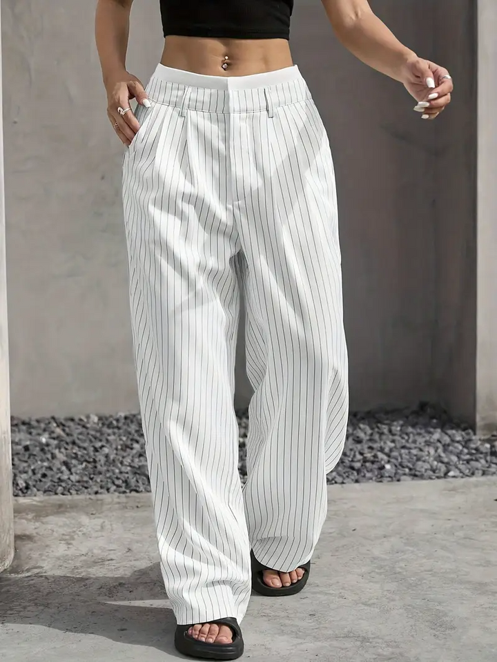 Full-length view of women's pinstripe wide-leg trousers, emphasizing their stylish drape.