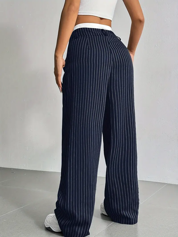 Chic women's pinstripe wide-leg trousers, showcasing their relaxed elegance and stylish cut.