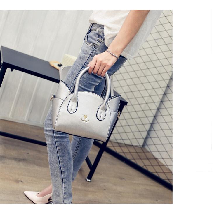 Pink women's crossbody bag featuring a playful cat accent, a charming faux leather everyday purse.