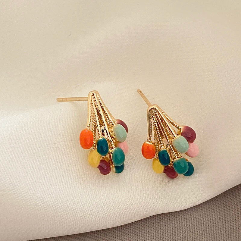Close-up of colorful enamel balloon stud earrings for women, featuring a playful gold-tone finish. Fun accessory.