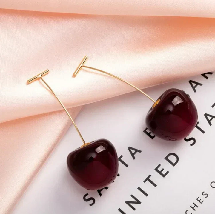Unique women's resin red cherry drop earrings, gold plated, adding a playful touch to any outfit.