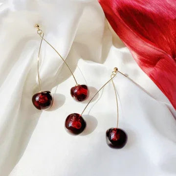Elegant women's gold plated drop earrings featuring playful red cherries, a unique and stylish accessory.