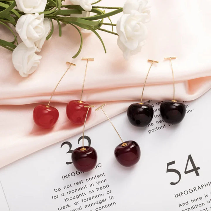 Playful women's red cherry drop earrings, gold plated, made from resin, a unique fashion jewelry piece.