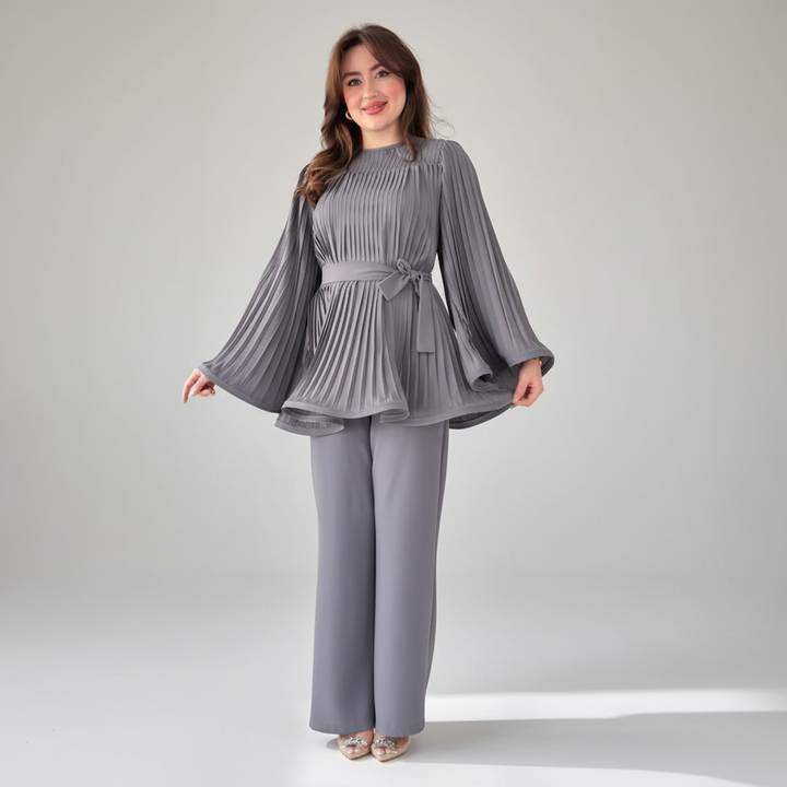 Fashionable women's two-piece outfit with pleated blouse and wide leg pants.