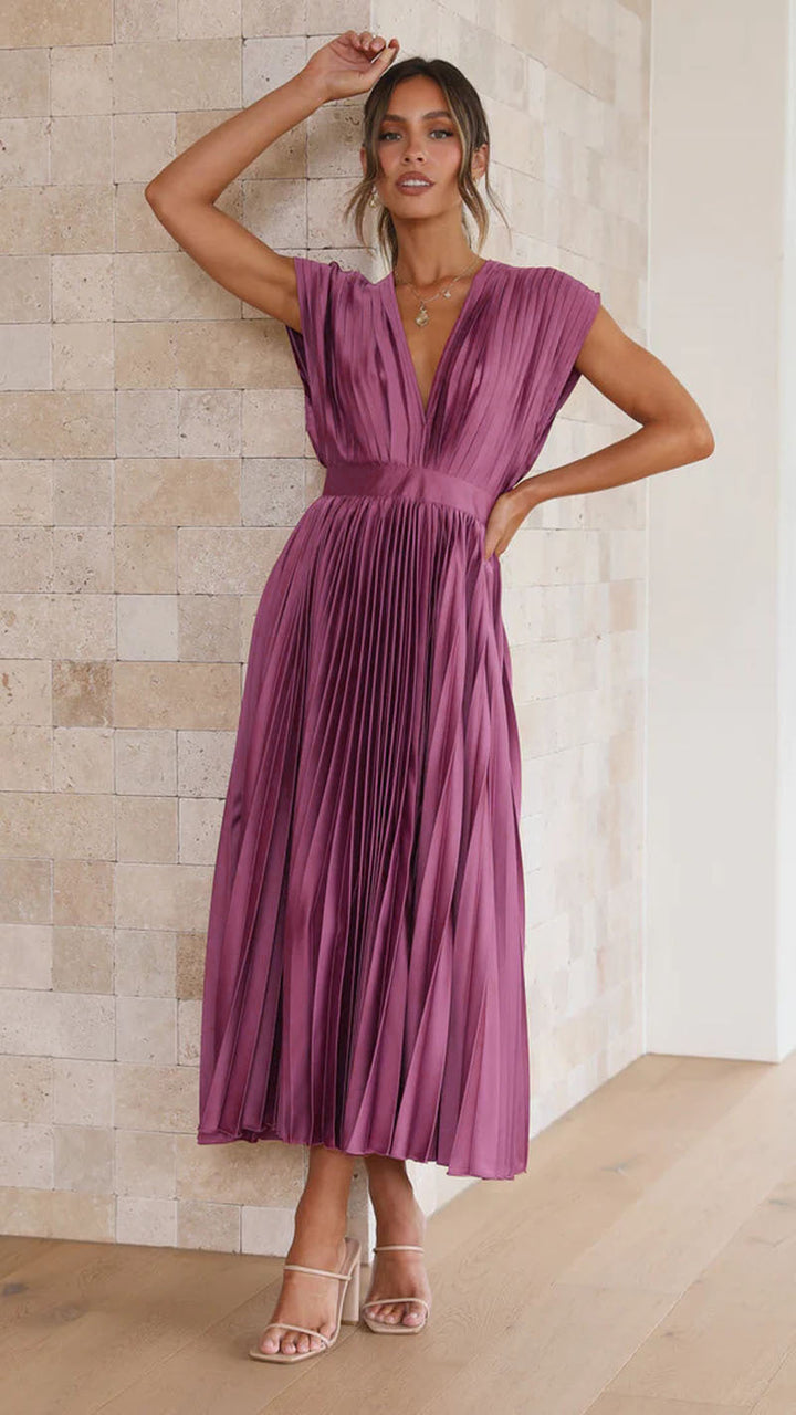 Effortless style: Woman wearing flared pleated V-neck midi dress, perfect for summer parties.