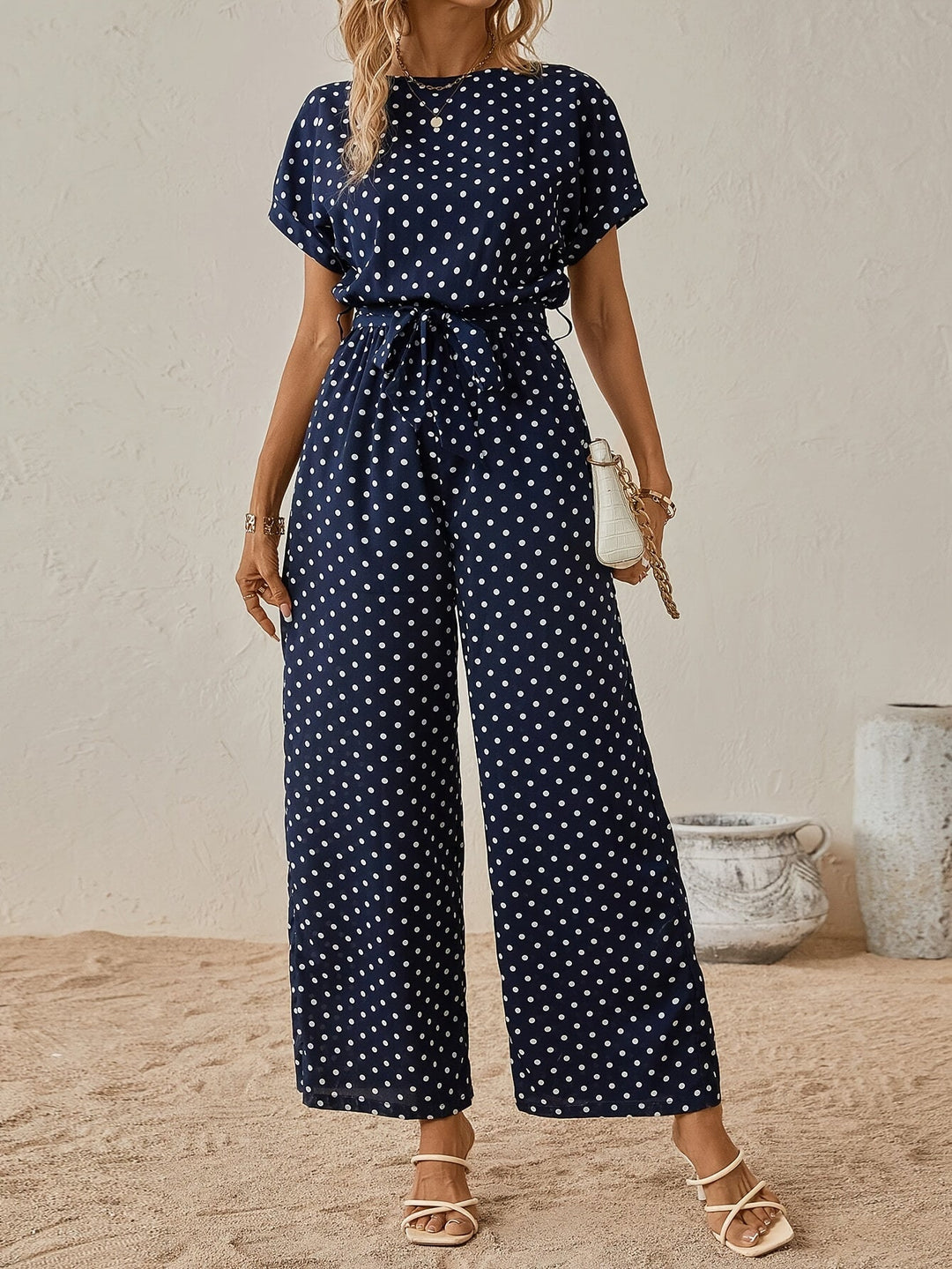 Trendy black and white polka dot women's jumpsuit featuring an elastic waist for comfortable, casual wear.