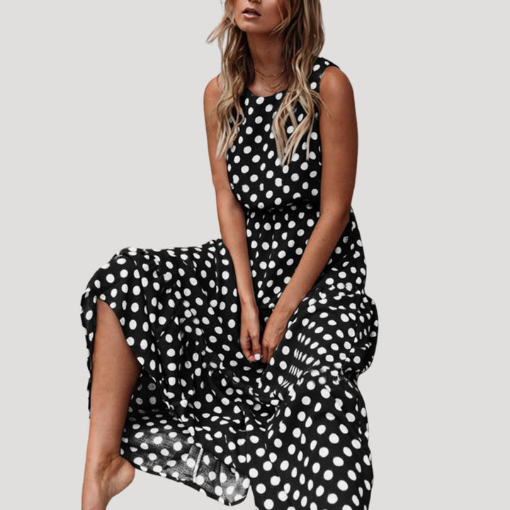 Elegant sleeveless A-line midi dress with polka dots. Ideal for vacation or a flowy summer day look.