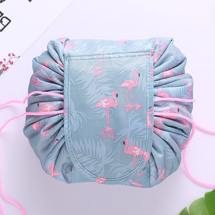 Compact women's travel cosmetic bag with easy drawstring closure. Grey flamingo portable organizer.