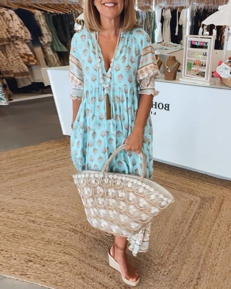 Women's printed midi dress with V-neck, lantern sleeves, and pockets. Effortless bohemian style.