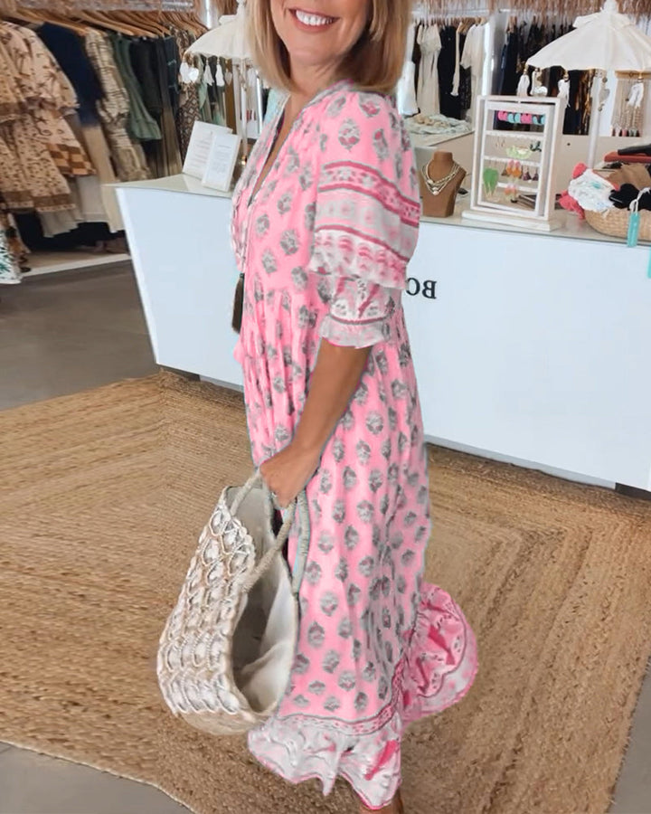 Vibrant printed midi dress for women. V-neck, lantern sleeves, and pockets, perfect for a bohemian summer look.