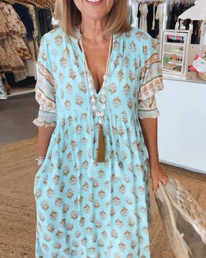 Comfortable flowy printed midi dress for women. Elegant everyday wear with V-neck, lantern sleeves, and pockets.
