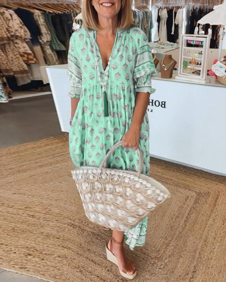 Women's bohemian printed midi dress with convenient pockets. V-neck, lantern sleeves, and flowy silhouette.