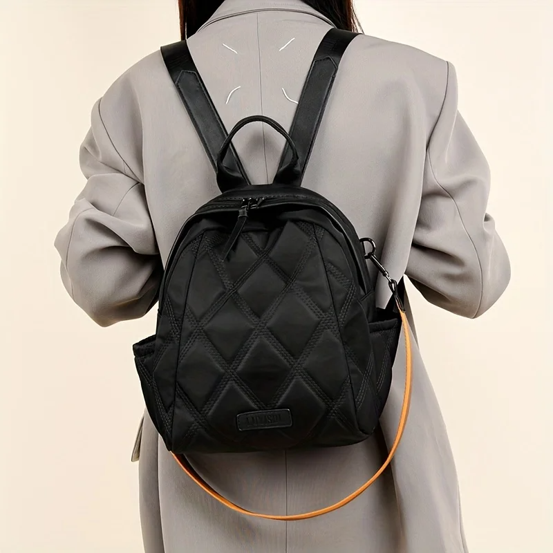 Women's quilted convertible backpack with discreet pocket. Functions as shoulder or crossbody bag.