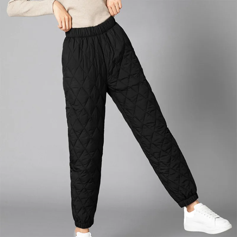 Close-up of quilted pattern on women's puffer joggers, soft fabric, warm winter essential.