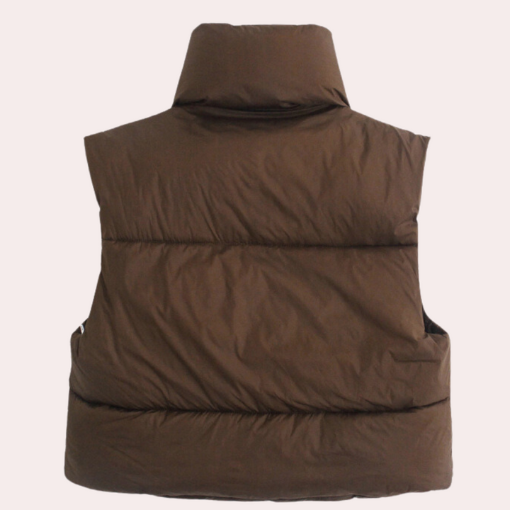 Close-up of a women's quilted gilet, showcasing its soft polyester fabric & chic short design. Versatile outerwear.